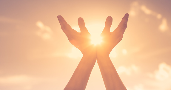 Hand up to the sun, spiritual light hope, and worshipping concept.