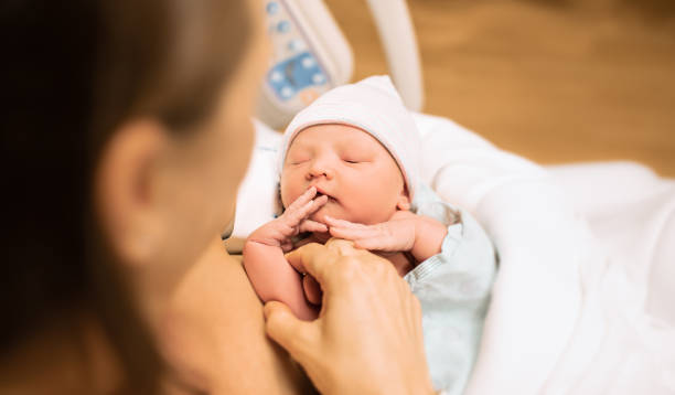 Mutter, die neugeborenes Baby im Krankenhausbett hält. – Foto