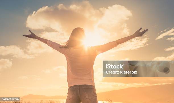 Young Woman With Hands Up The Morning Sun Light Finding Happiness Peace And Hope In Nature Stock Photo - Download Image Now