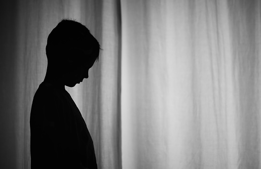 silhouette of sad lonely by at home in a dark room