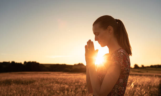 istock Woman with praying hands worshiping god 1486907471