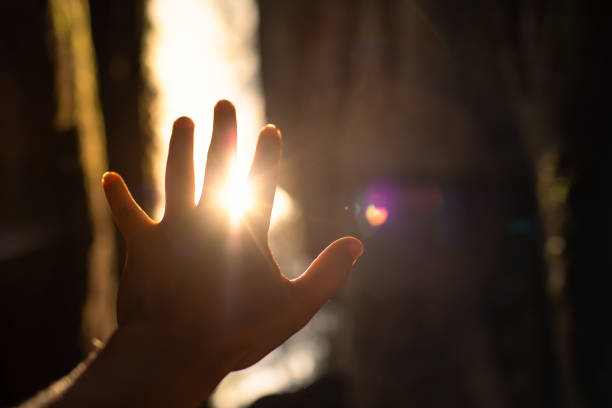 hand, die sich dem sonnenlicht entgegenstreckt - heaven women sunrise inspiration stock-fotos und bilder