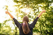 Woman in nature forest with thumbs up feeling positive,  inspired