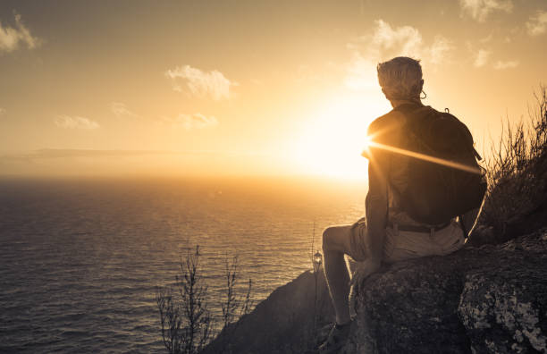 istock Hiker on mountain cliff looking out to sea 1486909742
