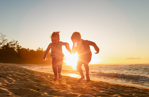 Happy children on a beach at sunset