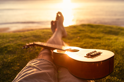 Man relaxing with guitar watching the sunset