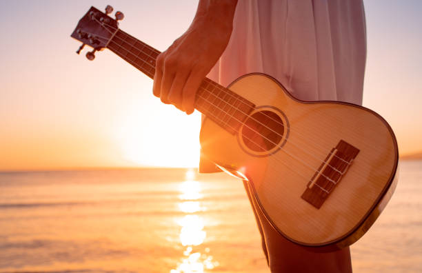 istock Female holding guitar on sunset beach, enjoying paradise 1486910153