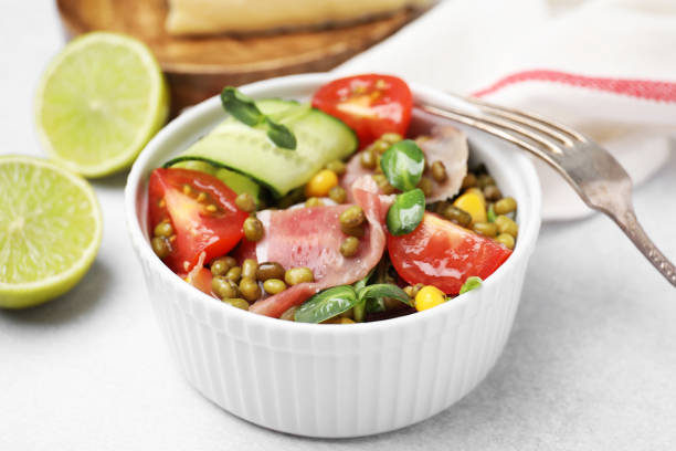 istock Bowl of salad with mung beans on white table, closeup 1486911239