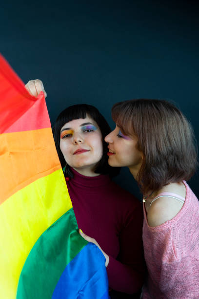 Two women wrapped in Pride Flag