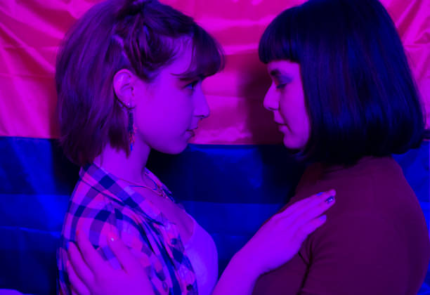 Two women wrapped in Pride Flag