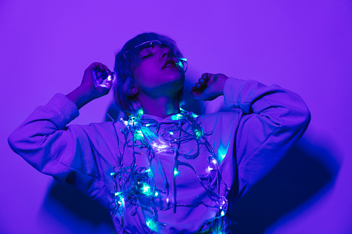 Young woman colorful lights studio shot