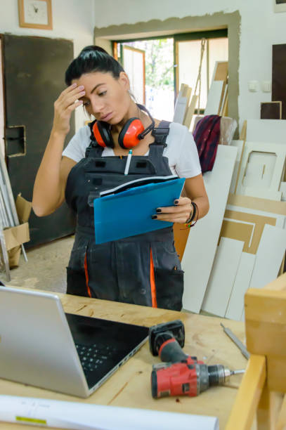 istock A Carpenter Woman is Looking at the Laptop in Workshop and Working on New Projects. 1486918732
