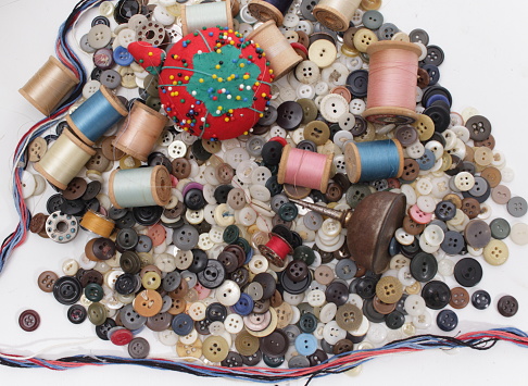 Different colors of linen and material old wooden spools and buttons