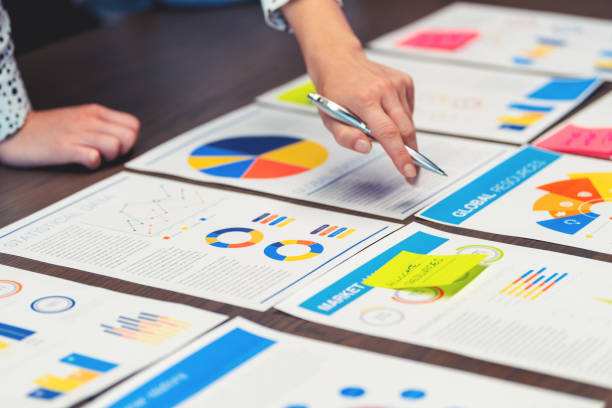 istock Paperwork and hands on a board room table at a business presentation or seminar. 1486919122