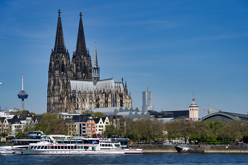 cologne, germany april 30 2023: Decorated excursion boats on the banks of the rhine in front of Cologne Cathedral in the old town of cologne