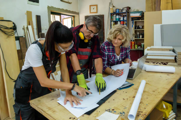 istock An Experienced Carpenter is Analyzing Project Plans with his Coworkers. 1486920077