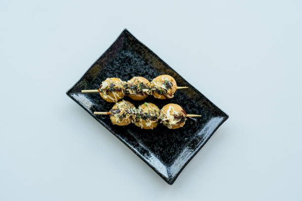 Japanese octopus balls TAKOYAKI Japanese octopus balls TAKOYAKI boat on white background cooking takoyaki is a ball shaped japanese snack stock pictures, royalty-free photos & images