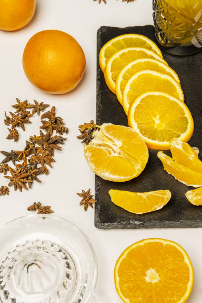 istock Some whole oranges with another peeled and another cut in half together with a quantity of star anise, a glass juicer and segments of fresh and succulent orange 1486926424