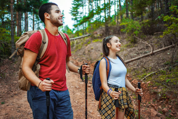 istock Young adventurous couple with backpacks hiking in the forest 1486932470
