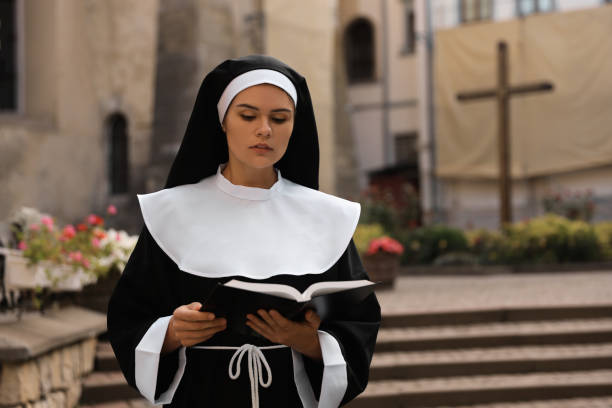 istock Young nun reading Bible near building outdoors. Space for text 1486933531