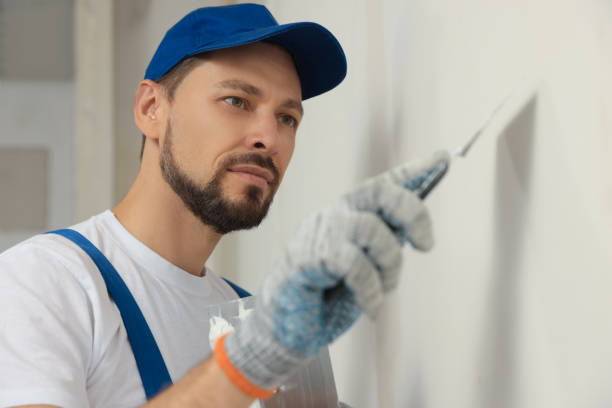 istock Professional worker plastering wall with putty knife indoors 1486933538