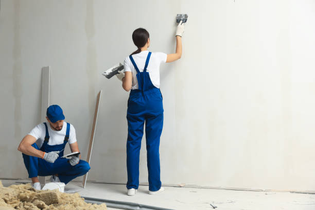 istock Professional workers plastering wall with putty knives indoors 1486933574