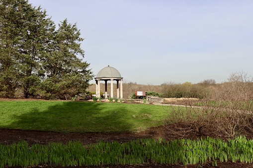 The cement gazebo in the park on a sunny day.