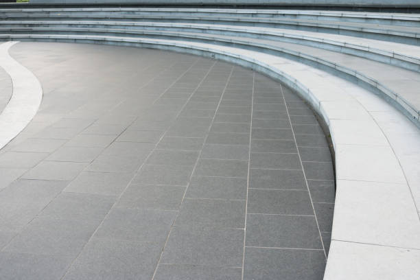istock Dark gray granite tiles floor with white stairway curved shape background. 1486944865