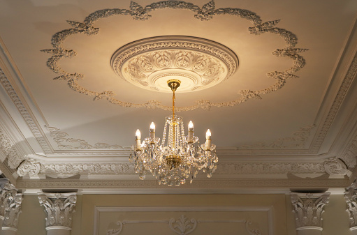 Crystal chandelier warm light luxury elegant style installed on ceiling in a room.