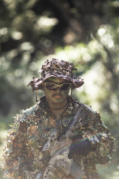 istock Full camouflage hunter with AR-15 in the woods 1486950666