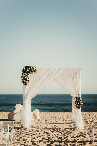 Wedding arch with flowers on the sand by the ocean