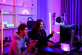 Couple e-sport gamer playing and helping clear stage challenge with happy enjoy feeling together in entertainment room