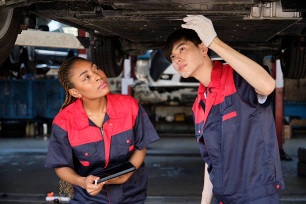 istock Two mechanic worker partners check car undercarriage at the service garage. 1486973788
