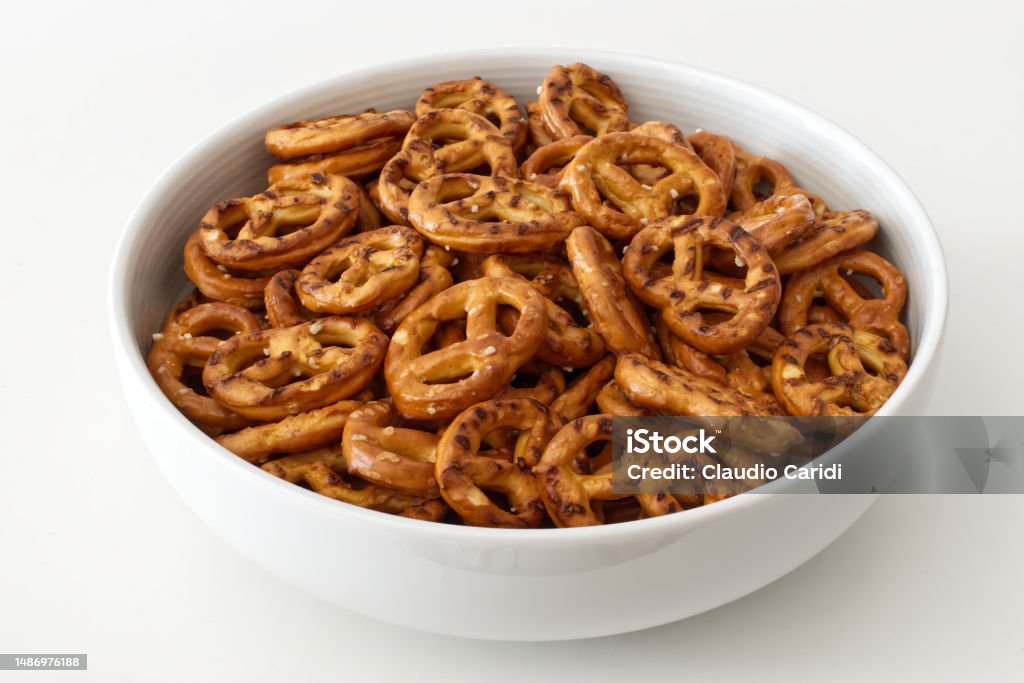 Salted savory mini pretzels in a bowl isolated on white background Appetizer Stock Photo