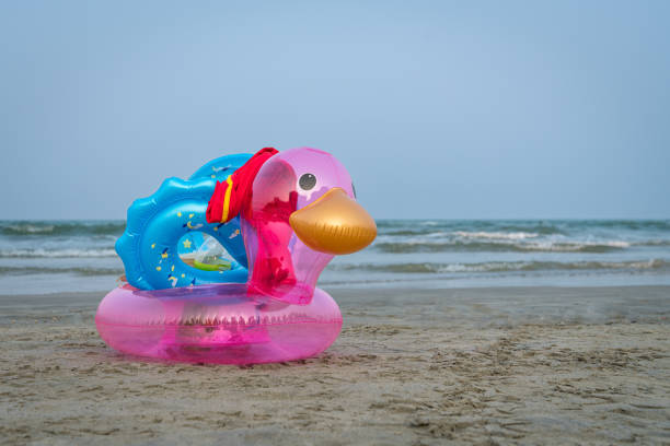 istock Inflatable duck on a sandy beach. Sea and blue sky at the background. 1486979097