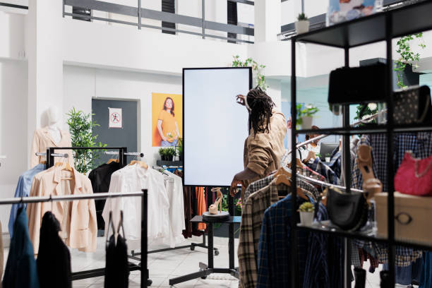 istock Customer pressing on smart whiteboard screen in clothing shop 1486984142