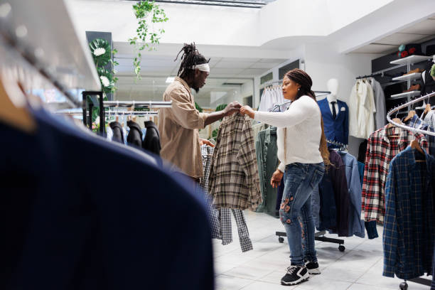 istock Customer getting help from girlfriend in choosing formal shirt 1486984205