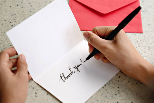 istock With a red envelope nearby, a woman's hands write a 