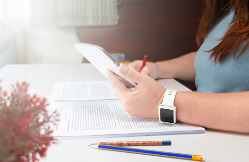 woman hand on English proofreading paperwork on table in office