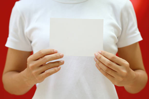 Woman's hand holding a blank card. Blank white card for design mockup stock photo