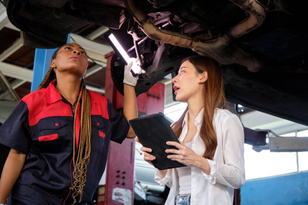 istock Asian female owner discusses with mechanical worker, check car undercarriage. 1486987437