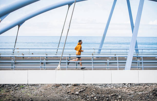 istock Man running on a bridge near the ocean. 1486989912