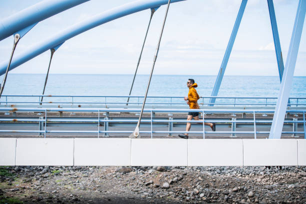 istock Man on a morning jog on a bridge by the ocean. 1486989915