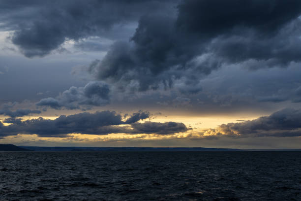 Dramatic stormy dark cloudy sky over sea, natural photo background.