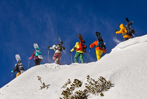 Bansko, Pirin mountains, Bulgaria - 18.03.2023 
Group of back country snowboarders climbing Mt Todorka ridge towards the starting point of Bansko Freeride World Qualifier competition