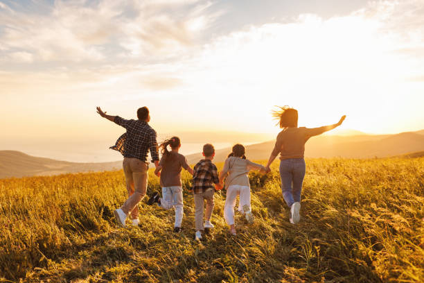 Happy large family: mother, father, children son and daughters on sunset Happy large family: mother, father, children son and  daughters running on nature  on sunset family activity stock pictures, royalty-free photos & images