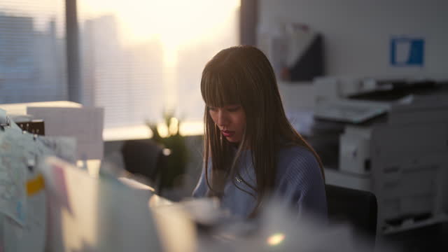 Businesswoman working in office during sunset