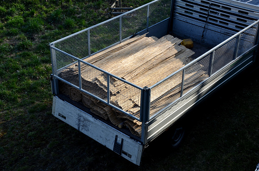 protecting the tree, the bark of the trunk from damage or overheating and damage from frost cracks. on the bed of a truck with sidewalls. reed rolls, shade and are visible on fences