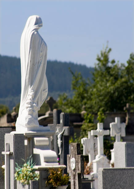 Ancient cemetery white marble sculpture and  row of crosses  in the sunlight in Lugo city, Galicia, Spain.