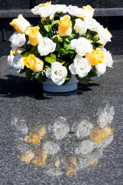 istock Flower arrangement on granite tombstone in a graveyard. 1486999608